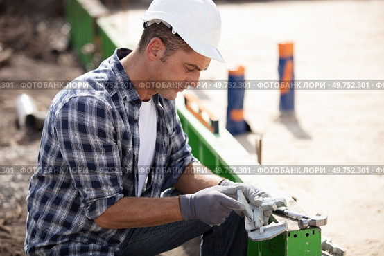 construction worker laying foundations at building site. Стоковое фото, агентство Ingram Publishing / Фотобанк Лори
