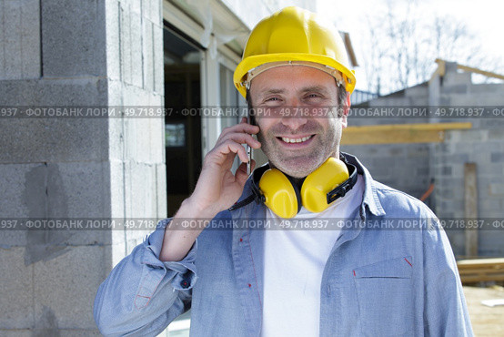construction worker on the phone with noise cancelling earphones. Стоковое фото, агентство Ingram Publishing / Фотобанк Лори