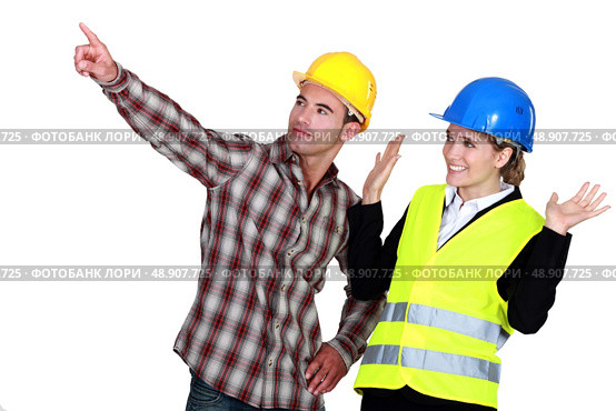 Construction worker pointing out a problem while his co-worker denies any involvement. Стоковое фото, агентство Ingram Publishing / Фотобанк Лори