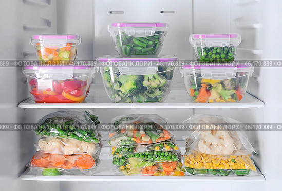 Containers and plastic bags with frozen vegetables in refrigerator. Стоковое фото, фотограф Pixel_shot / Фотобанк Лори