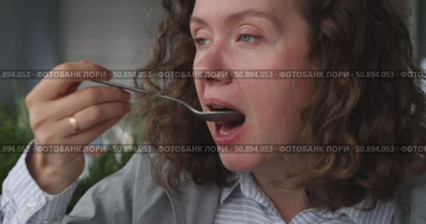 Contemplative woman engaging delicious snack in lively urban setting, surrounded by natures beauty. Стоковое видео, видеограф Ekaterina Demidova / Фотобанк Лори