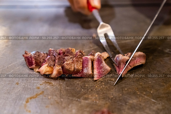 Cooking of beef teppanyaki recipe japanese grilled beef on cooking pan using scraper and knife. Стоковое фото, агентство Ingram Publishing / Фотобанк Лори