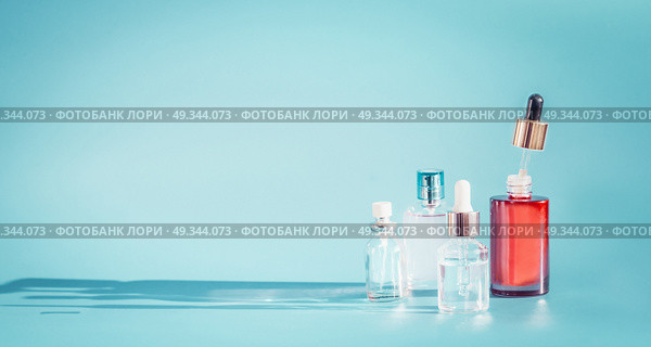 Cosmetic bottle products with liquid, pipette at blue background, front view.  Essence, toner or extract serum on table, front view. Beauty and modern skin care concept with copy space. Стоковое фото, агентство Ingram Publishing / Фотобанк Лори