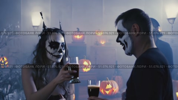Costumed attendees enjoy a Halloween celebration surrounded by glowing jack-o'-lanterns in a spooky atmosphere. Стоковое AI-видео, аниматор Данила Большаков / Фотобанк Лори