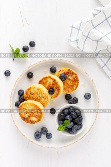 Cottage cheese or curd fritters with honey and fresh blueberry. Healthy diet food, breakfast. Top view. Стоковое фото, агентство Ingram Publishing / Фотобанк Лори