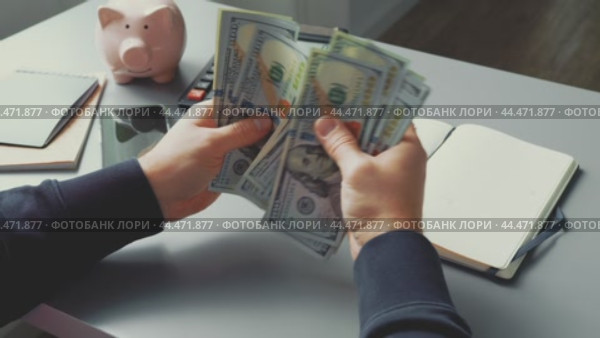 Counting cash and managing finances at a desk with notebook and calculator in view. Стоковое видео, видеограф Сергей Толмачёв / Фотобанк Лори