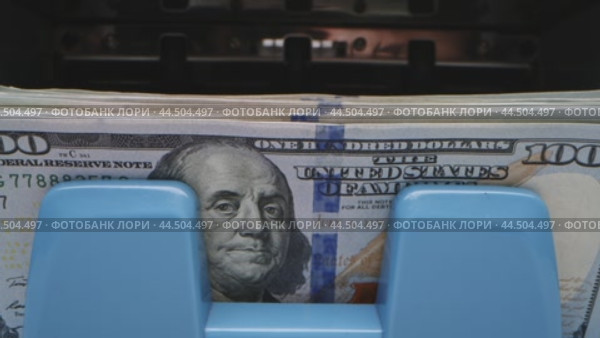 Counting cash in a bank with hundred dollar bills in a currency dispenser in a busy financial district. Стоковое видео, видеограф Сергей Толмачёв / Фотобанк Лори