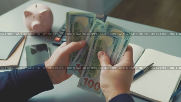 Counting cash while budgeting at a desk with savings tools and a calculator. Стоковое видео, видеограф Сергей Толмачёв / Фотобанк Лори
