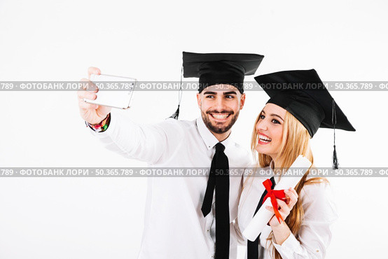 couple graduating taking selfie. Стоковое фото, агентство Ingram Publishing / Фотобанк Лори