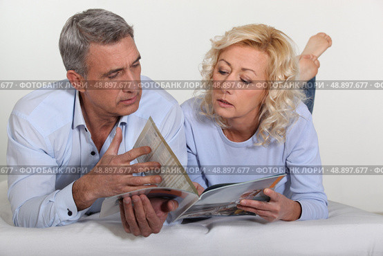 Couple looking at a catalogue. Стоковое фото, агентство Ingram Publishing / Фотобанк Лори