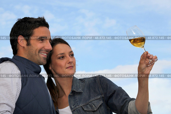 Couple looking at a glass of wine. Стоковое фото, агентство Ingram Publishing / Фотобанк Лори