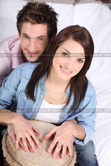 Couple playing a bongo drum. Стоковое фото, агентство Ingram Publishing / Фотобанк Лори
