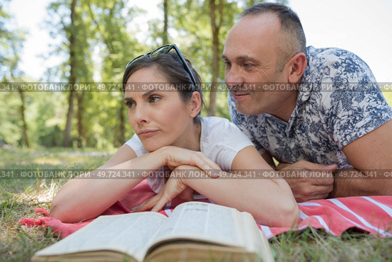 couple reading on picnic blanket. Стоковое фото, агентство Ingram Publishing / Фотобанк Лори