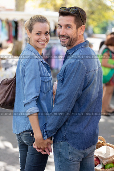 couple walking by flea market in late afternoon. Стоковое фото, агентство Ingram Publishing / Фотобанк Лори
