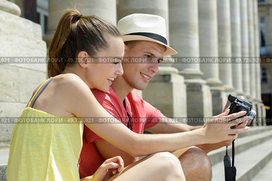 couple watching photos from travel on digital camera. Стоковое фото, агентство Ingram Publishing / Фотобанк Лори