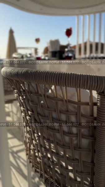 Cozy Lounge Zone At The Sidewalk Cafeteria With Chaise Lounge, Parasol Umbrellas And Decorative Garlands Refreshing cocktails with straws and paper umbrellas are standing on the bar counter on a beautiful tropical beach with palm trees and turquoise Sea High Resolution image of wooden table foreground with beach bar counter, ocean background. Tropical resort, summer vacation concept. Travel advertising banner, Стоковое видео, видеограф Zita Khasanova / Фотобанк Лори