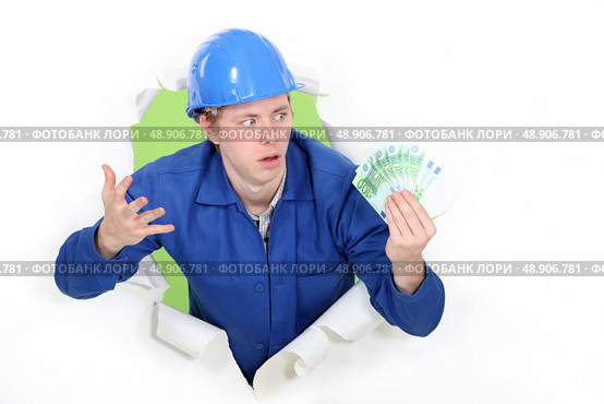 craftsman holding bills and looking surprised. Стоковое фото, агентство Ingram Publishing / Фотобанк Лори
