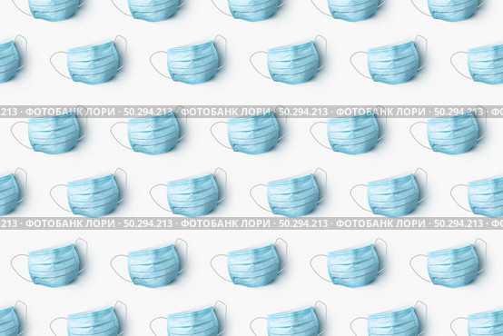 Creative pattern from medical antibacterial protective blue face masks on a white background. Flat lay Concept of prevention from respiratory sickness and viruses.. Health care pattern from medical masks on a white background. Стоковое фото, агентство Ingram Publishing / Фотобанк Лори