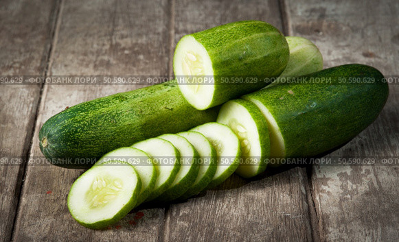 cucumber slices on wooden background. Стоковое фото, агентство Ingram Publishing / Фотобанк Лори