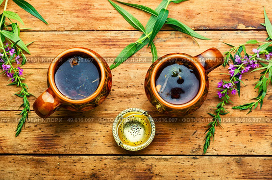 Cup of herbal tea on the table. Ivan tea or fireweed.Herbal medicine. Healing fireweed tea,rustic wooden table. Стоковое фото, агентство Ingram Publishing / Фотобанк Лори
