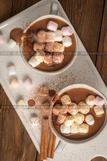 Cups of hot chocolate drink with marshmallows and cinnamon on brown wooden background. Стоковое фото, агентство Ingram Publishing / Фотобанк Лори