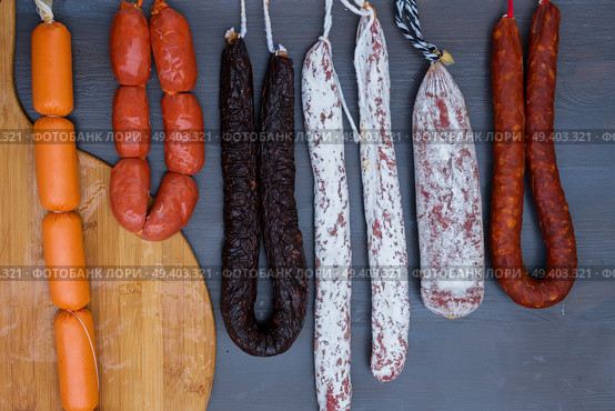 Cured meat and sausages hanging a rack at market.. Cured meat and sausages. Стоковое фото, агентство Ingram Publishing / Фотобанк Лори