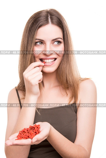 Cute girl eating a bunch of goji berries. Стоковое фото, агентство Ingram Publishing / Фотобанк Лори