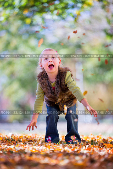 cute little girl throwing autumn leaves. Стоковое фото, фотограф Mariusz Blach / Smarterpix / Фотобанк Лори
