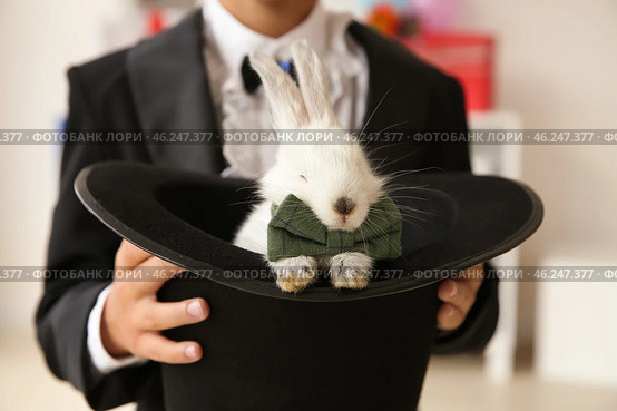 Cute little magician holding hat with rabbit indoors, closeup. Стоковое фото, фотограф Pixel_shot / Фотобанк Лори