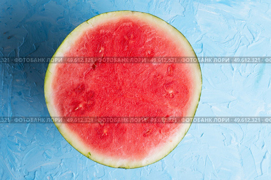 cutted half  part of  ripe  watermelon without pips  around blue background. Стоковое фото, агентство Ingram Publishing / Фотобанк Лори