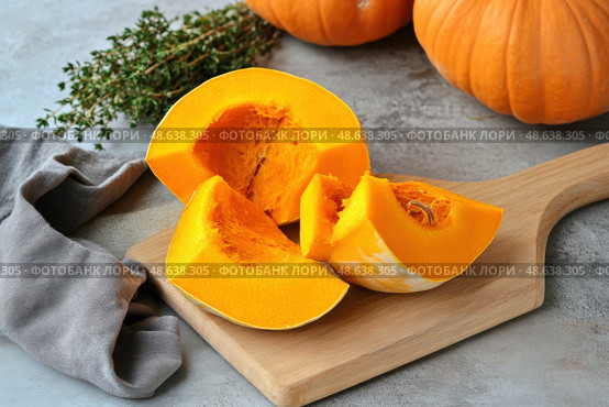 Cutting Fresh Pumpkins on Board. Baked pumpkin. Sliced raw Cucurbita maxima and spices for preparing soup, warm salad, fall dish. Thanksgiving food. Roasted vegetable in olive oil salt pepper, herbs. Стоковое AI-изображение, AI-художник Марина Демидюк / Фотобанк Лори