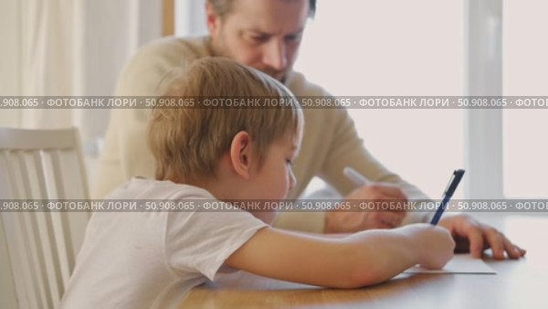 Dad teaches his son writing and counting. Kids primary education. Children learn, study in home school. Daddy male helping teaching little child boy support studying, learning homework. Knowledge day. Стоковое видео, видеограф Марина Демидюк / Фотобанк Лори