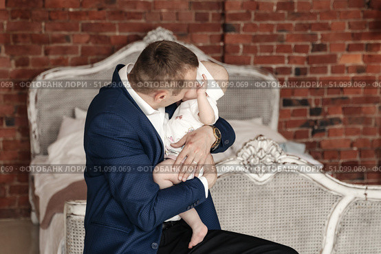 Daddy's Adoration Loving His Baby Daughter Near the Bed at Home. Стоковое фото, фотограф Aleksandr Golubev / Фотобанк Лори