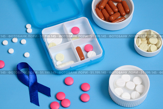 Daily pill organizer and blue awareness ribbon promoting colon cancer awareness. Стоковое фото, фотограф Дмитрий Цветков / Фотобанк Лори