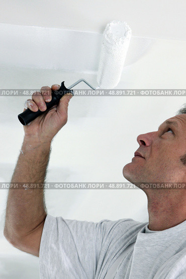 Decorator repainting ceiling. Стоковое фото, агентство Ingram Publishing / Фотобанк Лори