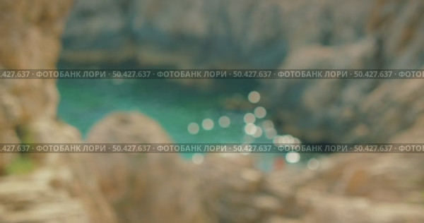 Defocused view of shimmering water in rocky cove on sunny day in summer Capri. Стоковое видео, видеограф Igor Tichonow / Фотобанк Лори