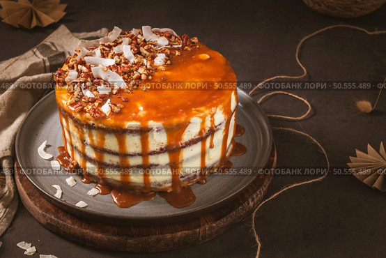 Delicious caramel cake with small pieces of pecan nuts and coconut shavings. Стоковое фото, агентство Ingram Publishing / Фотобанк Лори
