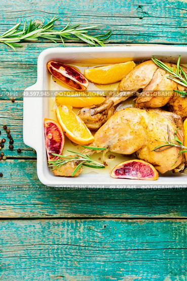 Delicious chicken baked with oranges and rosemary in a baking dish.Baked chicken drumstick. Tasty chicken drumstick baked with oranges. Стоковое фото, агентство Ingram Publishing / Фотобанк Лори