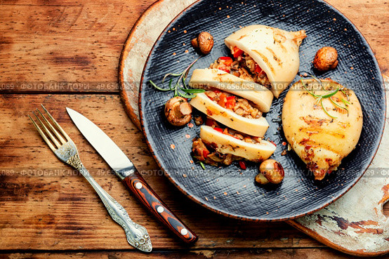 Delicious grilled squids with vegetable stuffing. Roasted stuffed squid on a plate.Top view. Fried squid with vegetables, stuffed calamari. Стоковое фото, агентство Ingram Publishing / Фотобанк Лори