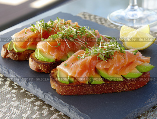 Delicious open-faced sandwiches topped with smoked salmon and avocado. Стоковое AI-изображение, AI-художник Татьяна  Бральнина / Фотобанк Лори