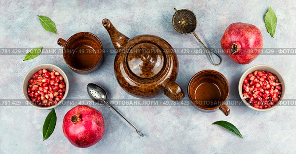 Delicious red tea and pomegranate on table in the teakettle.. Tea With Pomegranate Seeds. Стоковое фото, агентство Ingram Publishing / Фотобанк Лори