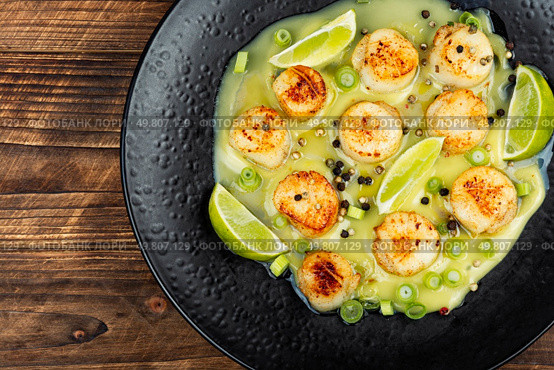 Delicious roasted scallops with a basil sauce and lime. Scallops cooked in butter.. Seared scallops on a plate. Стоковое фото, агентство Ingram Publishing / Фотобанк Лори