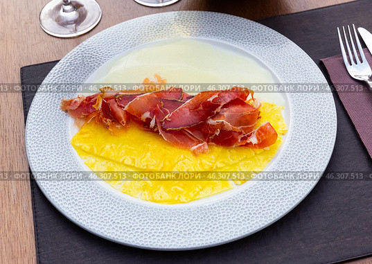Delicious serving of pineapple and melon carpaccio with thinly sliced prosciutto. Стоковое фото, фотограф Яков Филимонов / Фотобанк Лори