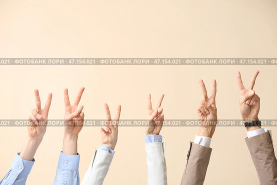 Деловые люди показывают победный жест на бежевом фоне. Стоковое фото, фотограф Pixel_shot / Фотобанк Лори