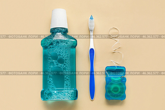 Dental floss, tooth brush and rinse on beige background. Стоковое фото, фотограф Pixel_shot / Фотобанк Лори
