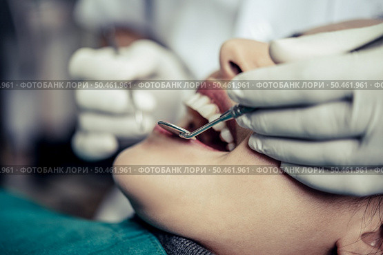 Dentists treat patients’ teeth. Стоковое фото, агентство Ingram Publishing / Фотобанк Лори