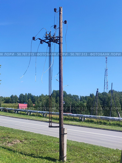 Деревянная опора с обрезанными проводами. A wooden pole with cut wires. Стоковое фото, фотограф Денис Баданин / Фотобанк Лори