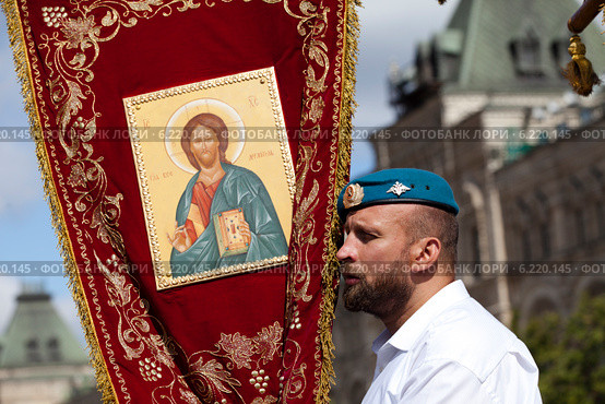 Десантник ВДВ держит православную хоругвь во время богослужения на Лобном месте на Красной площади города Москвы в день Святого Илии пророка и ВДВ (2013 год). Редакционное фото, фотограф Николай Винокуров / Фотобанк Лори