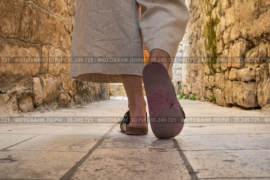 Detail shot of female legs wearing comfortable travel sandals walking on old medieval cobblestones street dring sightseeing city tour. Travel, tourism and adventure concept. Стоковое фото, фотограф Matej Kastelic / Фотобанк Лори