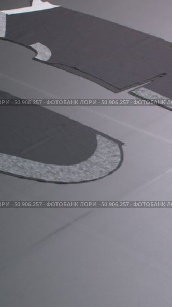 Details of a man's black jacket laid out on a tape for dubbing at a garment factory. Стоковое видео, видеограф Дмитрий Нечаев / Фотобанк Лори